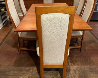1970's Modernist Teak Dining Room Table with 6 Chairs. Includes extra leaf (not shown). Measurements as shown: 31"H x 38"W x 70"L. Chairs measure 42" tall to the top of the back x 19"W at widest point of seat. Image 1.  Table and 6 Chairs $2400.