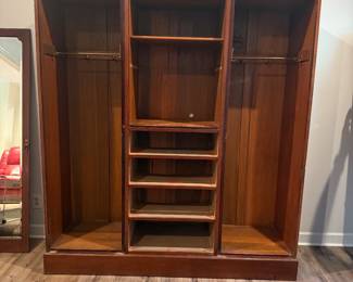 Edwardian Solid Mahogany Wardrobe, Circa 1800's. There are 2 of these unique pieces. This piece is raised on a deep Plinth base and separates for ease of transporting, 2 hanging areas behind the mirrored doors with an upper shelf, 4 drawers and above that a shelved opening. Perfect for those older homes with small closets.