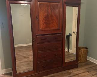 Edwardian Solid Mahogany Wardrobe, Circa 1800's. There are 2 of these unique pieces. This piece is raised on a deep Plinth base and separates for ease of transporting, 2 hanging areas behind the mirrored doors with an upper shelf, 4 drawers and above that a shelved opening. Perfect for those older homes with small closets.