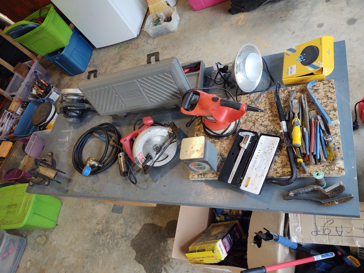 Bench with vice, several handheld tools, chisels and crowbars