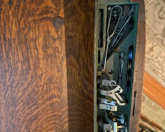 Four drawers of notions. The center drawer contains the original pressure feet, bobbins and attachments.