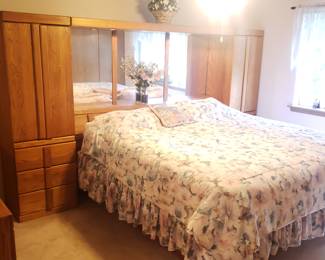 Oak bedroom set including wall unit, king mattress, under-bed storage and dresser with mirror. Available now by appointment.