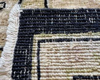 $400; black and cream rug with botanical design; professional cleaning recommended, but in good condition; approximately 12'x15'; close up of weaving on back side