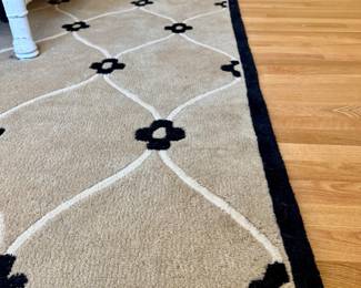 $300; black and tan floral wool rug that reverses to black and tan plain rug; approximately 8'x10'; close up of rug, thick pile. 