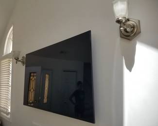 Flat screen TV with wall mount bracket; wall sconce lights
