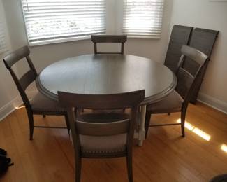Round dining table by Bassett seats 4 as shown; includes two bonus leaves