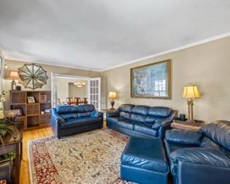 4-piece Leather Livingroom Set (includes sofa, loveseat, chair and ottoman) Also seen - console table, bookcase, wall art and rug.