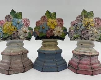 Three paint decorated iron door stops