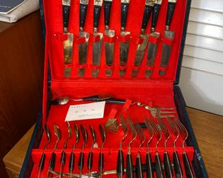 Thai cutlery set in golden metal accents and utensils with black handles