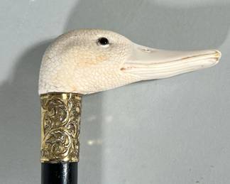 Antique Carved Bone Goose Head Cane | Carved bone head. Missing one glass eye. Brass etched Collar Black ebonized wood Shaft Brass ferrule - w. 4 x l. 34 x d. 4 in