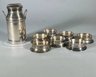 (8pc) Silver Candle Holders And Jug | Seven low rimmed candle holders and jug with lid made in India.
Dimensions: h. 8 x w. 5 in (Jug, 3” candle opening)