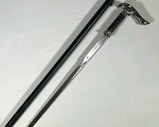 Kit Rae Carbon Steel Sword Cane | With decorative handle and faux leather wrapped shaft. Having intricate scrollwork etchings to blade and push button release for sword - w. 6 x l. 36 in