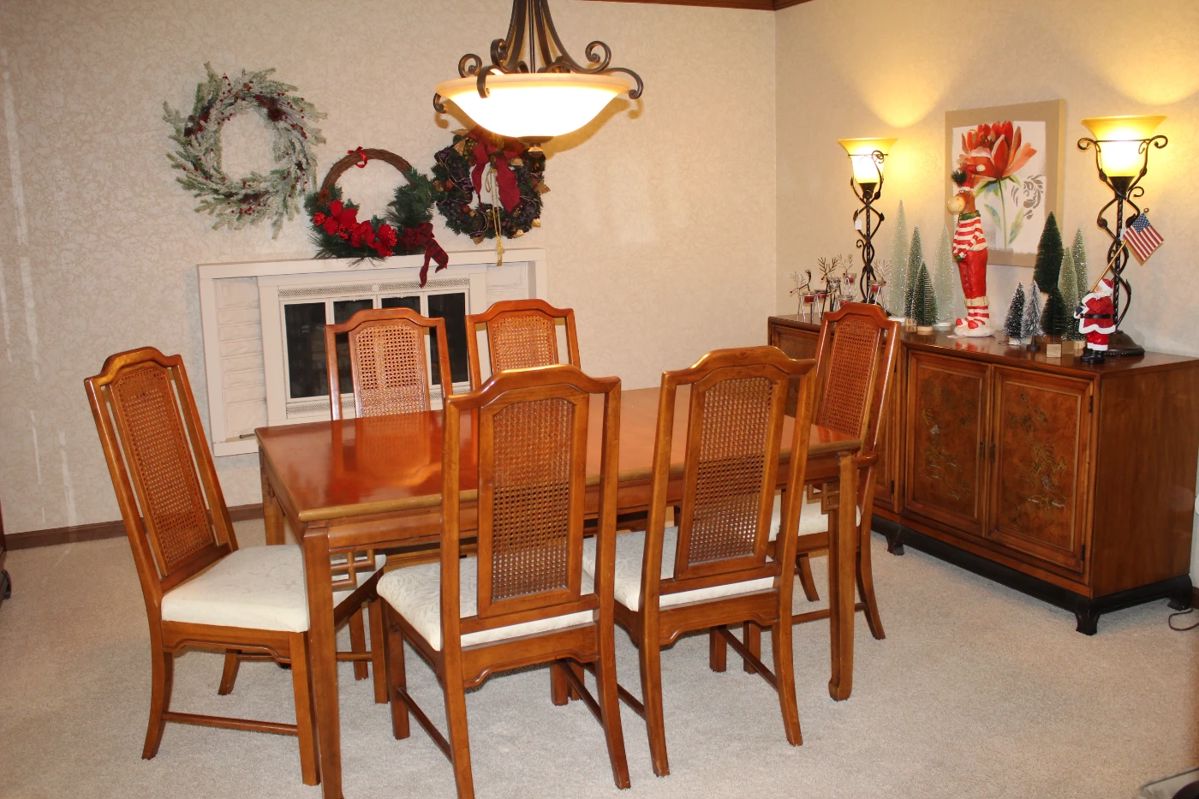 A 1970s Henry Link "Mandarin" dining room set which includes a rectangle table with two 18" leaves; one Captain chair and 5 side chairs, a double cabinet sideboard/buffet and a China cabinet with detailed fretwork.  