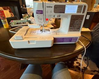 Excellent Working Condition! Was in its original packing as if it had never been used. White and purple sewing machine with digital display. Features include embroidery and sewing capabilities, various stitching options. Includes operation manual and USB connection guide, along with a large embroidery hoop. The machine has Brother branding and detailed settings on the front panel.

Brother brand sewing machine, model SE-400, featuring an LCD screen with purple accents. The machine has various buttons and knobs for stitch selection and settings. Included is an embroidery hoop, operation manual, and instructional materials. The visible stitches on fabric are red, showcasing different patterns, and the machine is primarily white with silver and purple details. 