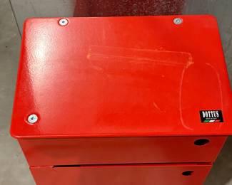 A red metal storage cabinet featuring five drawers. Each drawer has a circular handle hole. The top is smooth and flat, with visible screws securing it. The brand logo 'DOTTUS' is displayed on the top front.