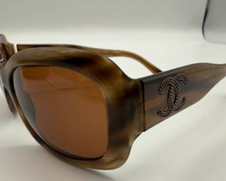 Chanel Sunglasses. Oversized sunglasses featuring a brown gradient lens, made of a brown tortoiseshell-like material. The frame has a smooth, glossy finish with a distinctive shape. Side arms are adorned with an embossed Chanel logo and feature additional branding on the inner arm. Comes with a velvet Gucci case, with a blue interior. Minor condition issue, small scratches on one edge, see photos for details.