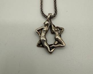 This is a beautiful sterling Star of David pendant featuring a man and a woman entwined. The pendant is suspended on a 23" chain. 