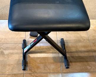 A black digital piano featuring a full keyboard with white and black keys. The brand name 'Yamaha' is clearly visible on the front of the piano. The model number 'P-45' is printed on one side. The piano has a sleek design with a sturdy black base. An adjustable black music bench is included, with a rectangular seat and a folding X-frame for support.