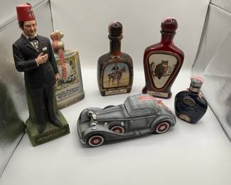 This is a collection of vintage novelty decanters, including a shriner, a vintage Rolls Royce and more! 