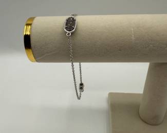Beautiful Kendra Scott adjustable bracelet featuring a reversible charm, crystals on one side and filagree on the other. Very good condition.