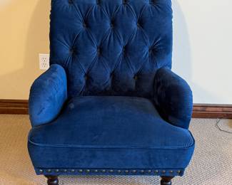 Beautiful tufted armchair featuring a deep blue velvet upholstery and stylish wood legs. Ideal for adding a pop of color to any space