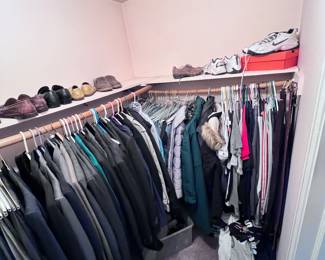 Closet filled with formal menswear, summer fall winter clothing, and men’s shoes