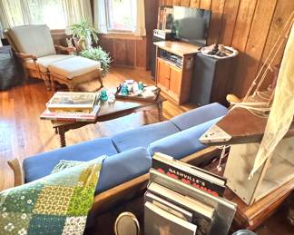 Vintage Wood-Paneled Living Room with Retro Decor and Handmade Quilt