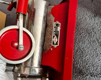 The Metal Ware Corporation of Two Rivers, Wisconsin produced the B-30 model toy steam engine during the first half of the 20th century, beginning in the 1920s. This toy steam engine’s boiler was electrically heated, with the heating element inside the red cast iron base.
