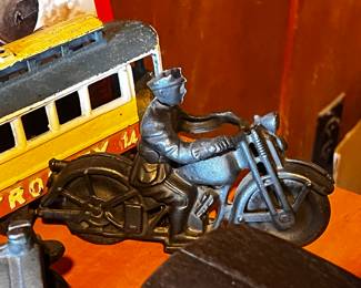 Cast Iron Toys: Several cast iron vehicles, including a circus wagon, cars, a horse-drawn carriage, and a train engine