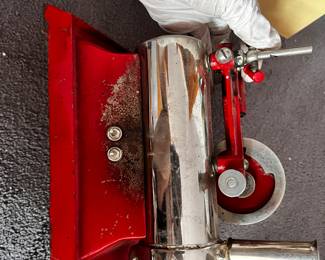 The Metal Ware Corporation of Two Rivers, Wisconsin produced the B-30 model toy steam engine during the first half of the 20th century, beginning in the 1920s. This toy steam engine’s boiler was electrically heated, with the heating element inside the red cast iron base.