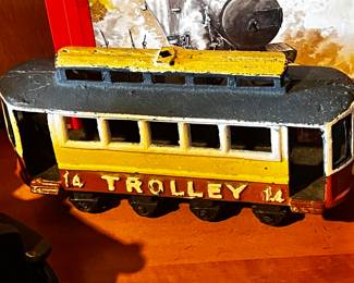 Cast Iron Toys: Several cast iron vehicles, including a circus wagon, cars, a horse-drawn carriage, and a train engine