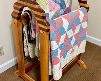 Handcrafted wooden quilt rack with handstitched quilts