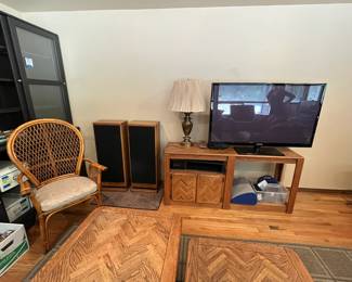 plasma TV with stand, speakers, wicker chair, cabinets with sliding doors