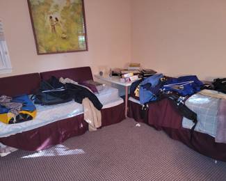 2 single beds under all those piles. Pillows on the right make it a day bed