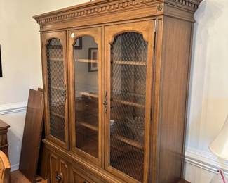 C34 - $75. Thomasville China Cabinet - Lighted. Moves in 2 pieces. Assembled it measures 58" wide x 16" deep x 75.5" tall. Has glass shelves inside (not adjustable).
