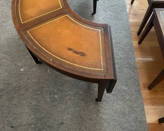 C58 - $50. Mahogany Half Circle Leather Top Coffee Table. Measures 4' x 14" deep x 16.5" tall. Each leaf adds 11.25" to each end if extended.