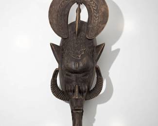 A Carved Wood African Senufo Mask With Protruding Horns And Bird Atop The Head
