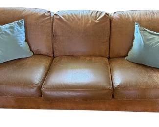 Brown Sofa With 2 Blue Throw Pillows 