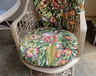 Tan cabana chair with tropical cushion.