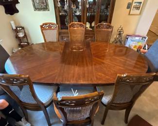 cherry wood oval dining table with 6 cane back chairs
