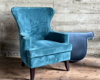 This lot features a vintage velvet wingback chair with wood legs and a fitted seat cushion cover. This velvet chair measures, 40” H x 31.5” W x 25” D.