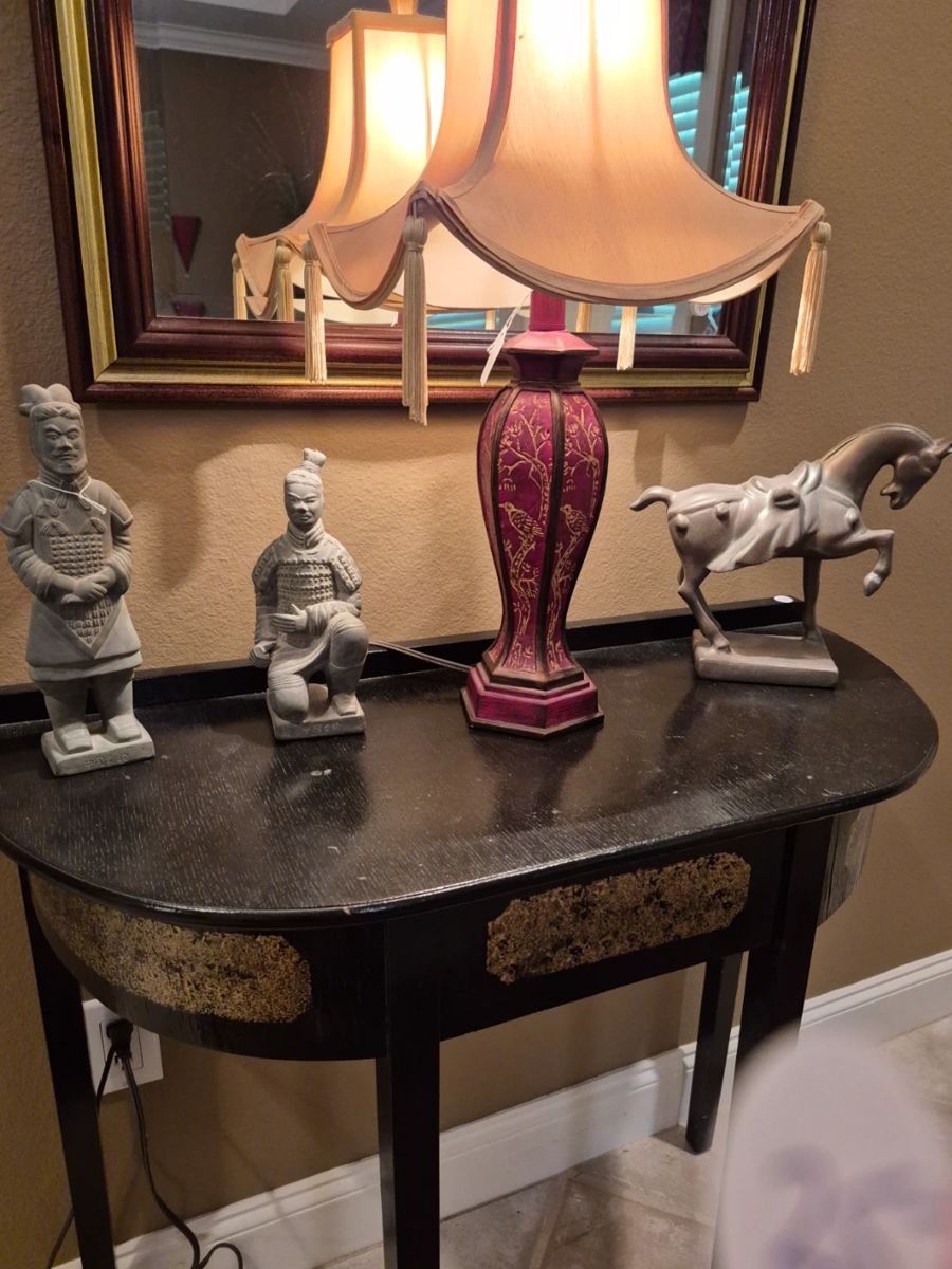 This fine old lacquer finished side table with some gold embelishment holds a Gorgeous tall Oriental lamp and large oriental figurines. 