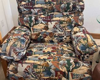 Your new favorite chair. Fabulous recliner upholstered in a sports theme fabric. Muted primary colors including red, green, brown, offwhite. This is a must see for your man cave, den, office or rec room.