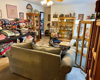 View of living room, 4 display cabinets, nativity sets, Blue Baroque Fostoria, pink depression, crochet afghans, quilts and other quilted items, blankets and throws