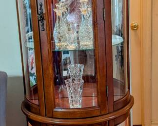 Lighted Round Front Display Cabinet - $200 - with Glass shelves and light in top and bottom. 20" wide, 12" deep, 65" tall.