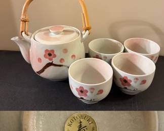 Kotobuki Japanese porcelain tea set, featuring a teapot with a bamboo handle and four teacups, all adorned with a cherry blossom