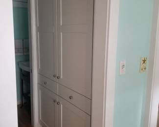 White contemporary kitchen includes a large pantry