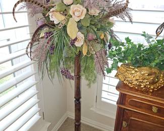 Tall plant stand with large floral and feather arrangement 