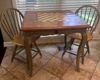 Chess/checkers table with two swivel chairs and game pieces in storage drawers