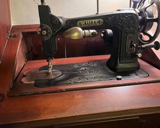 White Family Rotary sewing machine in sewing cabinet, early 1900's
